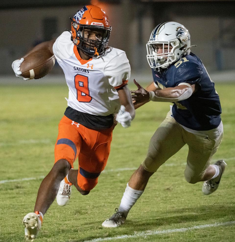 During Friday night's matchup, Escambia's Cam Mayo (no. 8) slips out of the grasp of Gulf Breeze middle linebacker Noah Perez (No. 51).