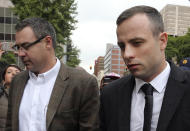 Oscar Pistorius, right, accompanied by relatives arrives at the high court in Pretoria, South Africa, Monday, April 14, 2014. Pistorius is charged with murder for the shooting death of his girlfriend, Reeva Steenkamp, on Valentines Day in 2013. (AP Photo/Themba Hadebe)