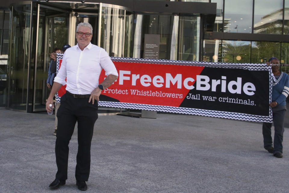 Australian army whistleblower David McBride is flanked by supporters as he leaves the Australian Capital Territory Supreme Court in Canberra, Australia, on Thursday, Nov. 7, 2019. McBride says he will defend himself at trial next year rather than face potential delays by hiring a lawyer with a security clearance. (AP Photo/Rod McGuirk)