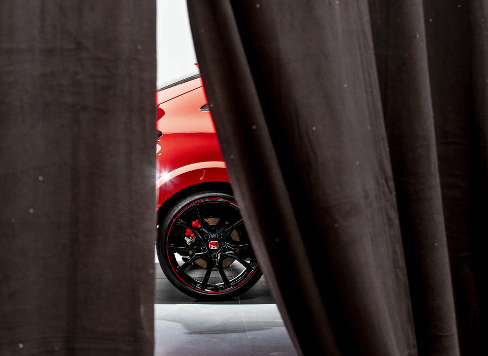 A red car stand behinds a curtain at the IAA Auto Show in Frankfurt, Germany, Monday, Sept. 9, 2019. The IAA officially starts with media days on Tuesday and Wednesday. (AP Photo/Michael Probst)