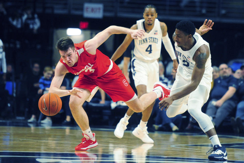 FILE - Cornell's Jimmy Boeheim, left, and Penn State's Izaiah Brockington (12) go after a loose ball during second half action of an NCAA college basketball game in State College, Pa., in this Sunday, Dec. 29, 2019, file photo. Jimmy Boeheim is transferring to Syracuse to play for his father and with his younger brother after three seasons at Cornell. Coach Jim Boeheim's oldest son made the announcement Friday, April 16, 2021, on Instagram. (AP Photo/Gary M. Baranec, File)