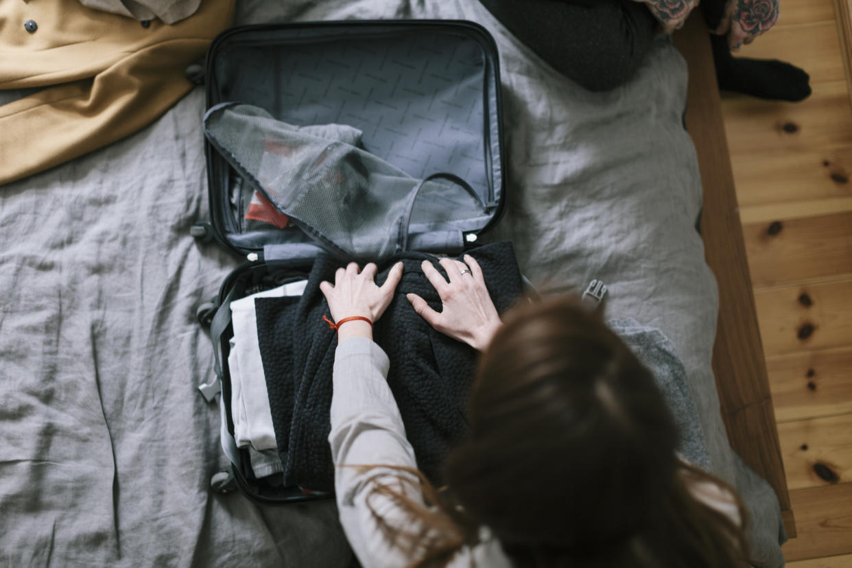 Woman packing a carry-on luggage for a trip.