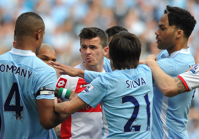 Queens Park Rangers' English midfielder Joey Barton (2nd L) clashes with Manchester City's Belgian defender Vincent Kompany (L) during the English Premier League football match between Manchester City and Queens Park Rangers at The Etihad stadium in Manchester, north-west England on May 13, 2012. AFP PHOTO/PAUL ELLIS RESTRICTED TO EDITORIAL USE. No use with unauthorized audio, video, data, fixture lists, club/league logos or 'live' services. Online in-match use limited to 45 images, no video emulation. No use in betting, games or single club/league/player publications.PAUL ELLIS/AFP/GettyImages