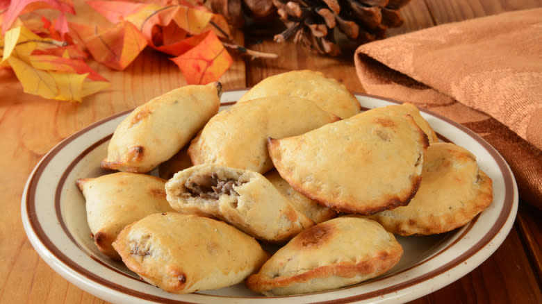 large Cornish-style pasty on a black dish