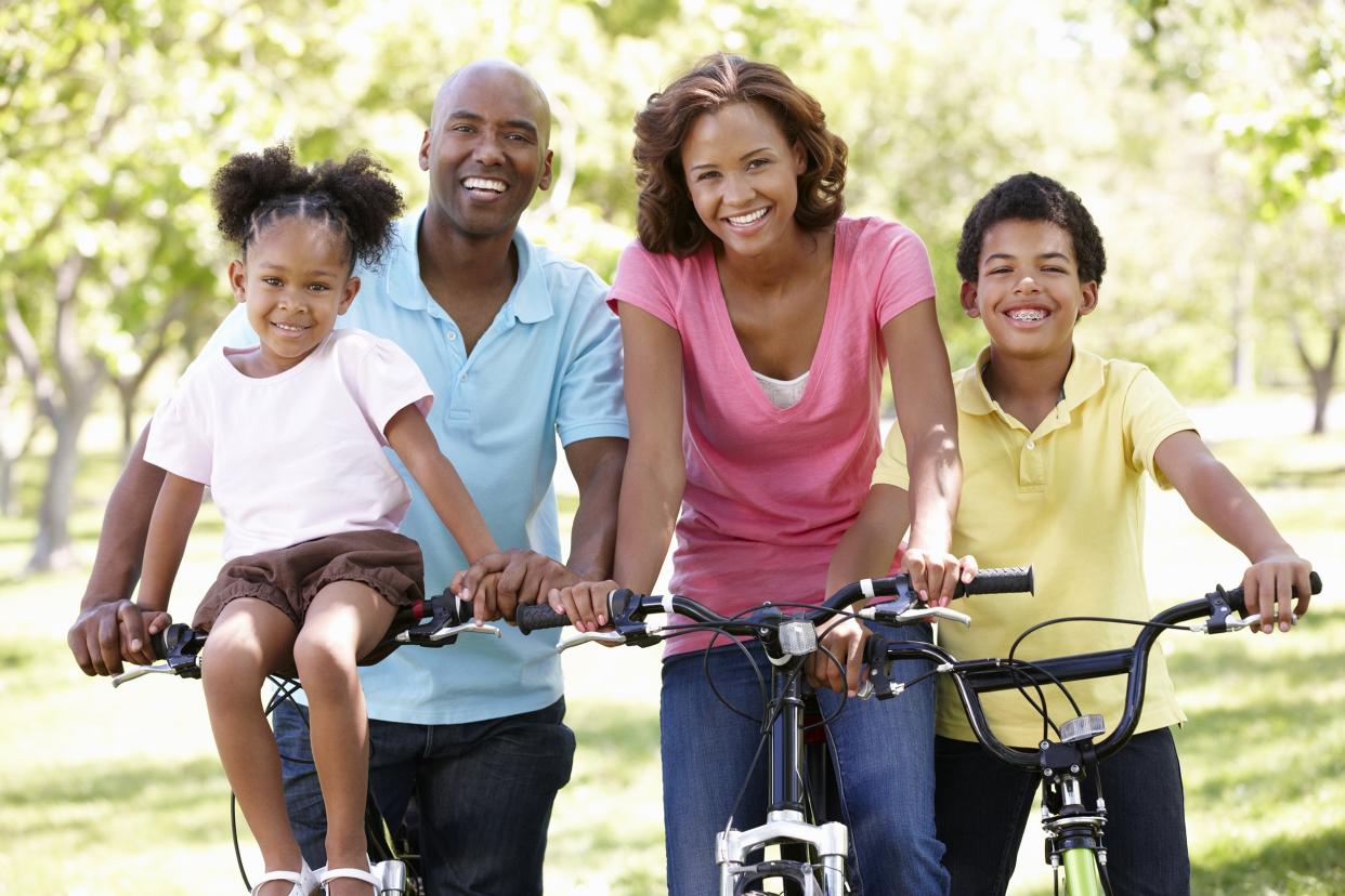 African American family riding bikes outside
