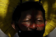 An Indigenous man wearing a mask amid the COVID-19 pandemic takes part in a protest against Brazilian President Jair Bolsonaro's proposals to allow mining on Indigenous lands, at the entrance of the Chamber of Deputies in Brasilia, Brazil, Wednesday, June 16, 2021. (AP Photo/Eraldo Peres)