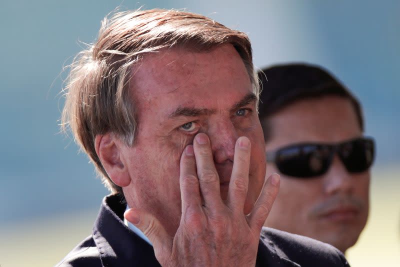 Brazil's President Jair Bolsonaro gestures while meets supporters as he leaves Alvorada Palace, as the spread of coronavirus disease (COVID-19) continues, in Brasilia