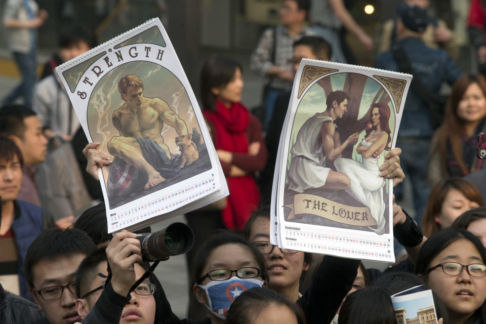 In this Monday, March 24, 2014 photo, a fan holds up posters during a publicity event ahead of the April release of the movie "Captain America: The Winter Soldier" in Beijing. Captain America and Spiderman are seeking to dominate the Chinese box office in the coming weeks, proving that U.S. patriotic superheroes can overcome China’s leeriness of foreign films if they promise big money. Chinese authorities, wary of outside cultural influences and competition, restrict the number of foreign movies shown in the mainland’s cinemas to 34 each year. (AP Photo/Ng Han Guan)