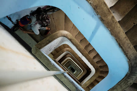 A boy climbs stairs holding a bike at the abandoned Prestes Maia textile factory occupied by a homeless movement in downtown Sao Paulo, Brazil, May 10, 2018. REUTERS/Nacho Doce