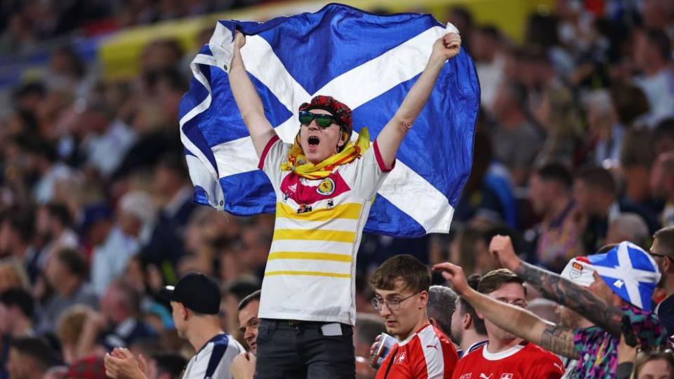 A Scotland fan holding a Saltire