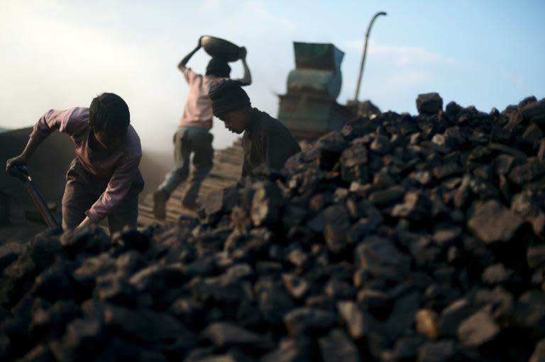 Indian children carry coal in baskets at a road side coal depot in the East Jaintia Hills district of the Indian state of Meghalaya on January 30, 2013