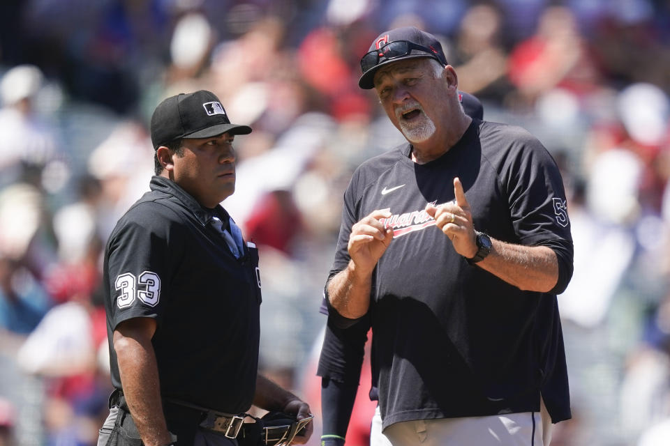 Cleveland Guardians pitching coach Carl Willis, right, argues with an umpire after Los Angeles Angels' Kyren Paris advanced to third on a balk call during the third inning of a baseball game, Sunday, Sept. 10, 2023, in Anaheim, Calif. (AP Photo/Ryan Sun)