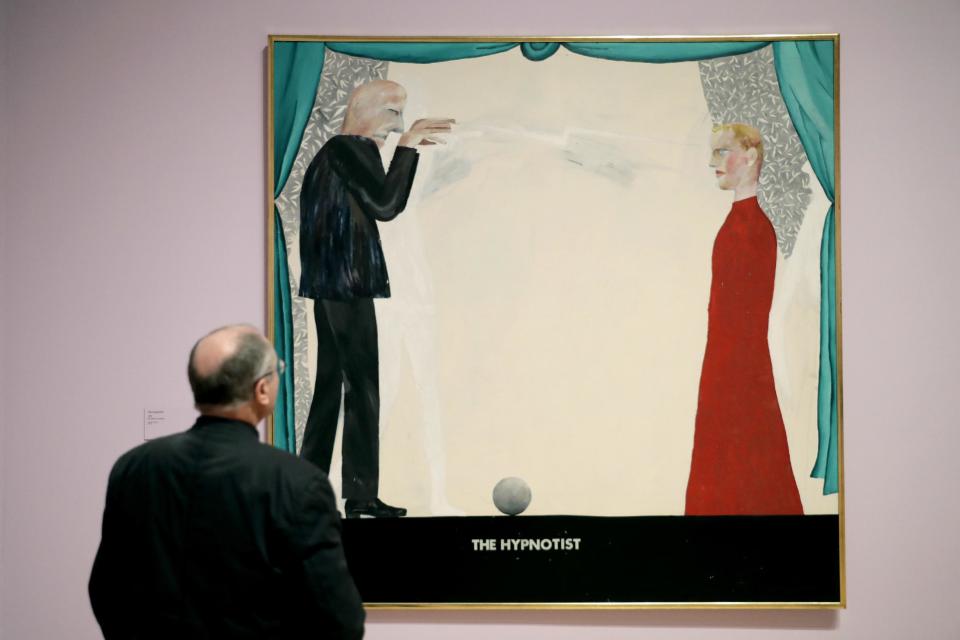 A man looks at British artist David Hockney's "The Hypnotist" during a media preview to promote the largest-ever retrospective of his work at Tate Britain gallery in London, Monday, Feb. 6, 2017. The exhibition, which opens to the public from February 9 and runs until May 29, celebrates the 79-year-old's achievement in painting, drawing, photography and video. (AP Photo/Matt Dunham)