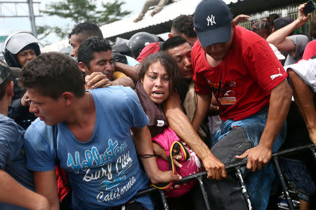 Honduran migrants, part of a caravan trying to reach the U.S., storm a border checkpoint in Guatemala, in Ciudad Hidalgo, Mexico October 19, 2018. REUTERS/Edgard Garrido