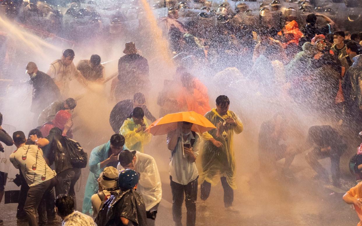 Pro democracy demonstrators face water canons as police try to clear the protest venue in Bangkok - AP