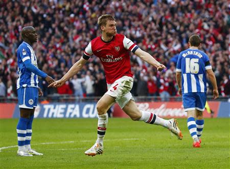 Arsenal's Per Mertesacker celebrates his goal against Wigan Athletic during their English FA Cup semi-final soccer match at Wembley Stadium in London April 12, 2014. REUTERS/Eddie Keogh