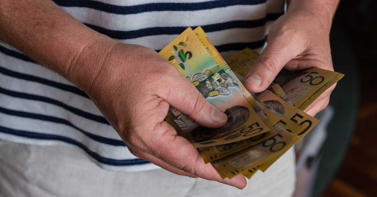 Hands holding $50 notes