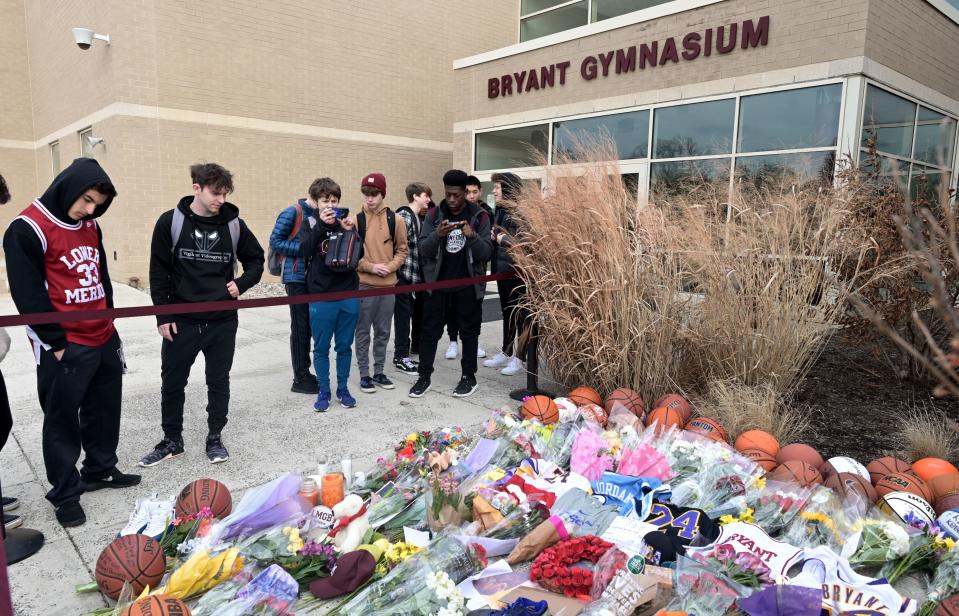 People pay their respects outside Bryant Gymnasium at Lower Merion High School, where basketball legend Kobe Bryant formally attended school, after his passing, on January 27, 2020 in Philadelphia, Pennsylvania. (Photo by Johannes EISELE / AFP)