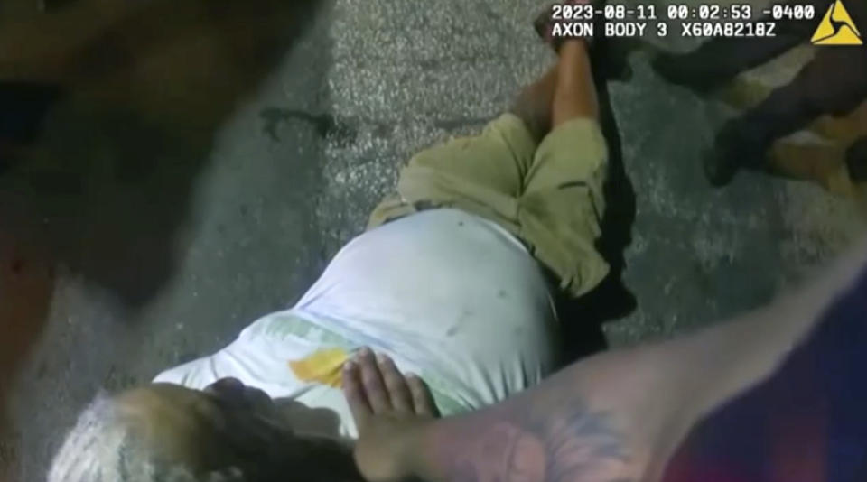 This image from bodycam video provided by the Atlanta Police Department shows Officer Kiran Kimbrough's hand on Johnny Hollman Sr. after an altercation on Aug. 10, 2023 in Atlanta. The police officer responding to a minor car crash deployed a Taser on the church deacon who disregarded multiple commands to sign a traffic ticket, shocking the man after he repeatedly said he could not breathe, police body camera video released Wednesday, Nov. 22, 2023 shows. Hollman Sr. became unresponsive during his arrest and later died. (Atlanta Police Department via AP)