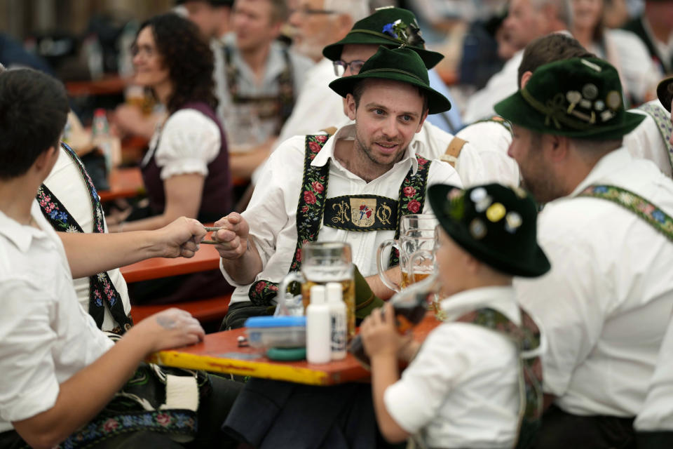 Competitors stretch their fingers as they prepare for a bout at the German Championships in Fingerhakeln_finger wrestling_ in Bernbeuren, Germany, Sunday, May 12, 2024. Competitors battled for the title in this traditional rural sport where the winner has to pull his opponent over a marked line on the table. (AP Photo/Matthias Schrader)