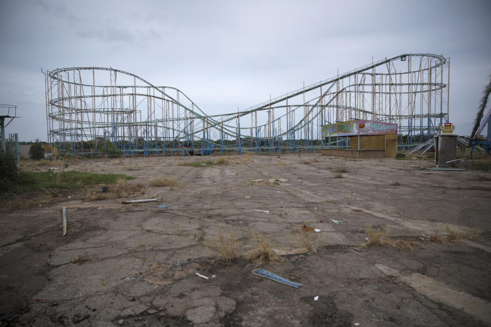 A roller coaster stands tall in the abandoned amusement park coined "Diversions Grano de Oro" in Maracaibo, Venezuela, May 23, 2019. Much of Venezuela is in a state of decay and abandonment, brought on by shortages of things that people need the most: cash, food, water, medicine, power, gasoline. (AP Photo/Rodrigo Abd)