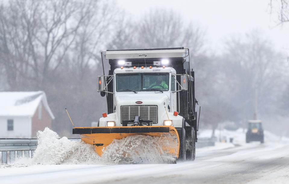 A snowplow scapes away the ice and snow from Clark Boulevard in Clarksville Monday afternoon. Although weather predictions had the area reaching up to eight inches of snow, far less fell during the day. Feb. 15, 2021