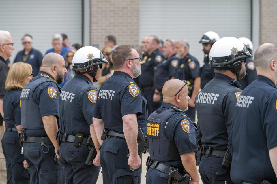 Harris County Sheriff's deputies stand at attention as the body Deputy John Hampton Coddou is transported to the Harris County Institute of Forensic Sciences, Tuesday, April 23, 2024, in Houston. Coddou was struck by a vehicle while assisting at a crash scene on the Grand Parkway at Cumberland Ridge Drive on Tuesday morning, and was transported by Life Flight to Memorial Hermann Medical Center where he later died. (Kirk Sides/Houston Chronicle via AP)