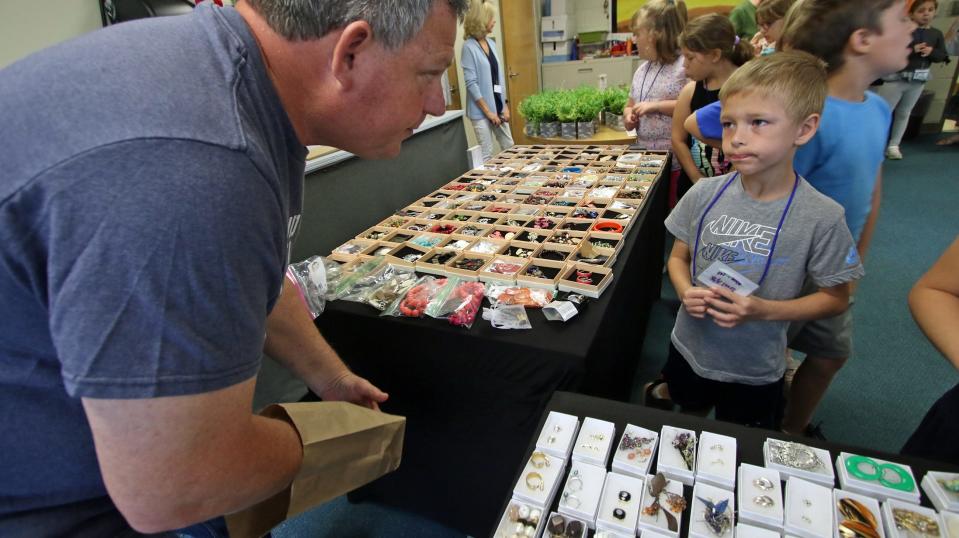 Doug Underwood attempts to help Grayson Wright pick out a piece of jewelry as a group of 2nd graders look to find a free gift to give for Mother’s Day Tuesday morning, May 7, 2024, at Cherryville Elementary School.