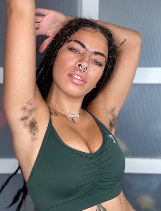 Gymshark model putting her arms up showing armpit hair