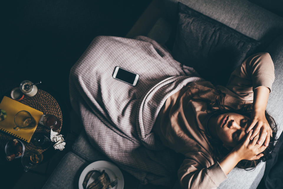 A woman looks depressed and sad while using her smartphone at home. (Getty Images) 