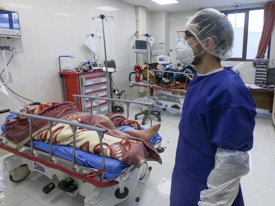 A nurse cares for patients in a ward dedicated for people infected with the coronavirus, at Forqani Hospital in Qom, 78 miles (125 kilometers) south of the capital Tehran, Iran, Wednesday, Feb. 26, 2020. Iran's president said Wednesday, that Tehran has no immediate plans to quarantine cities over the new coronavirus rapidly spreading across the country, even as the Islamic Republic suffers the highest death toll outside of China with 19 killed amid 139 cases confirmed on Wednesday. (Mohammad Mohsenzadeh/Mizan News Agency via AP )