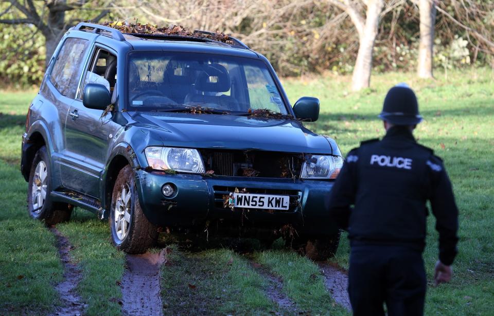 CHEW STOKE, UNITED KINGDOM - NOVEMBER 23: A police officer looks at a car, in which a man died after being trapped in flood waters, that has been dragged by a JCB from under a bridge where it had got wedged last night, near to a ford at Rectory Fields, in Chew Stoke, on November 23, 2012 in Somerset, England. The man died after becoming trapped in his 4x4 car in flood water last night as heavy rain continued to bring chaos to large parts of the country. (Photo by Matt Cardy/Getty Images)