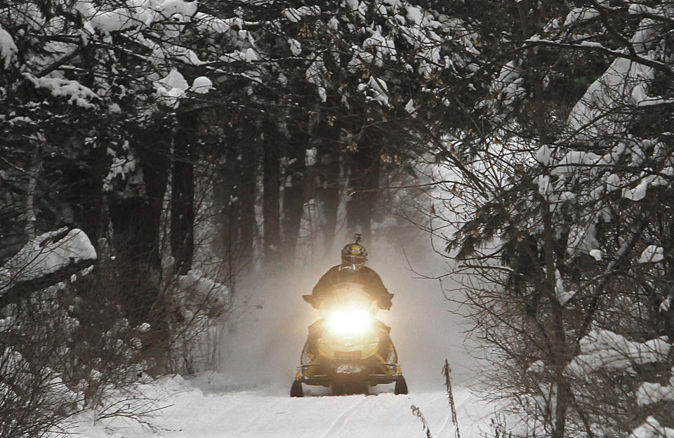 A snowmobile travels a newly-groomed trail on Monday, Dec. 31, 2012 in East Montpelier, Vt. The big snow is giving a big boost to snowmobilers across Vermont, New Hampshire and Maine. Parts of the region have received two feet of snow and more over the last several days, giving a boost to the sport that was hampered last season by a near-snowless winter. (AP Photo/Toby Talbot)