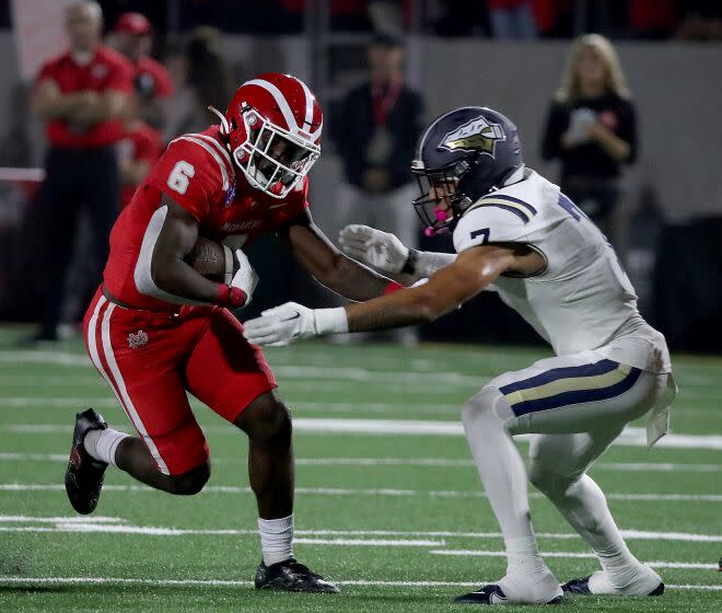 SANTA ANA, CALIF. - OPCT. 7, 2022. Mater Dei runnin bback Nathaniel Frazier tries to elude St.John Bosco defensive back Peyton Woodyard in the first half at Santa Ana Stadium on Friday night, Oct. 7, 2022. (Luis Sinco / Los Angeles Times)