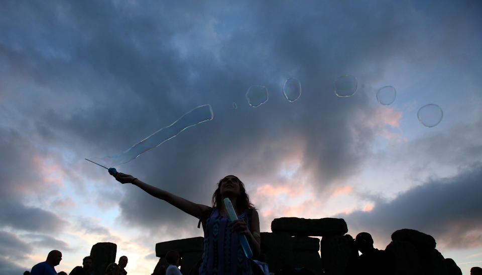 AMESBURY, ENGLAND - JUNE 20:  Robyn Smith makes bubbles as she waits for the arrival of the midsummer dawn at the megalithic monument of Stonehenge on June 20, 2013 near Amesbury, England. (Photo by Matt Cardy/Getty Images)