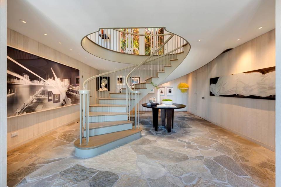 The entryway has a dramatic circular staircase.