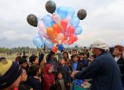 Afghan children buy balloons as they celebrate in anticipation of the U.S-Taliban agreement to allow a U.S. troop reduction and a permanent ceasefire, in Jalalabad