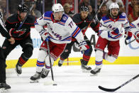 New York Rangers' Frank Vatrano (77) skates with the puck away from Carolina Hurricanes' Jordan Staal (11) during the first period of Game 1 of an NHL hockey Stanley Cup second-round playoff series in Raleigh, N.C., Wednesday, May 18, 2022. (AP Photo/Karl B DeBlaker)