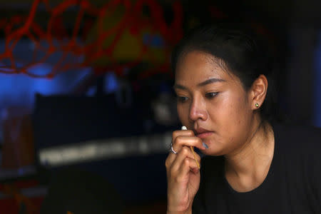 A mourner sniffs ammonia-soaked cotton wool handed out by medical rescue teams to help prevent fainting as she waits to pay her respects to Thailand's late King Bhumibol Adulyadej at the Grand Palace in Bangkok, Thailand, October 15, 2016. REUTERS/Athit Perawongmetha