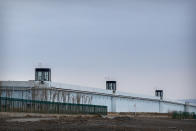 FILE - People stand in a guard tower on the perimeter wall of the Urumqi No. 3 Detention Center in Dabancheng in western China's Xinjiang Uyghur Autonomous Region on April 23, 2021. State officials took AP journalists on a tour of a "training center" turned detention site in Dabancheng sprawling over 220 acres and estimated to hold at least 10,000 prisoners - making it by far the largest detention center in China and among the largest on the planet. (AP Photo/Mark Schiefelbein, File)