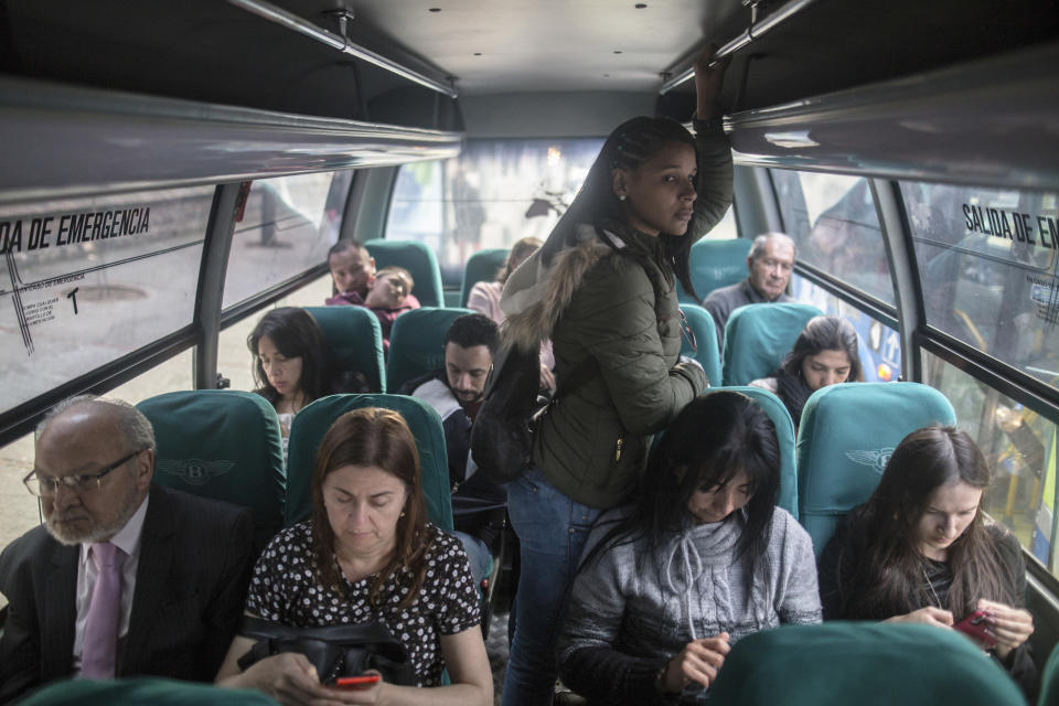 In this Dec. 11, 2018 photo, Venezuelan migrant Emili Espinoza commutes back home after a day's work at a health food restaurant in Bogota, Colombia. Like thousands of other Venezuelans migrating in the largest exodus in Latin America's modern history, Espinoza made an agonizing choice: To leave without her three children. (AP Photo/Ivan Valencia)