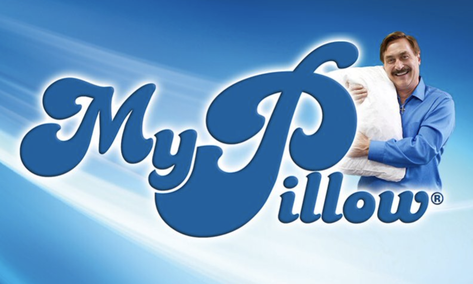 Pictured is Mike Lindell hugging a pillow in a promotional image for his company, My Pillow.