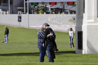 In this photo taken May 17, 2020, Lois England, left, and Ian Hendon kiss beside a large, white arch symbolizing U.S.-Canadian friendship after being reunited for a few hours at the border at Peace Arch Park following the longest separation of their three-year relationship, in Blaine, Wash. With the border closed to nonessential travel amid the global pandemic, families and couples across the continent have found themselves cut off from loved ones on the other side. But the recent reopening of Peace Arch Park, which spans from Blaine into Surrey, British Columbia, at the far western end of the 3,987-mile contiguous border, has given at least a few separated parents, siblings, lovers and friends a rare chance for some better-than-Skype visits. (AP Photo/Elaine Thompson)