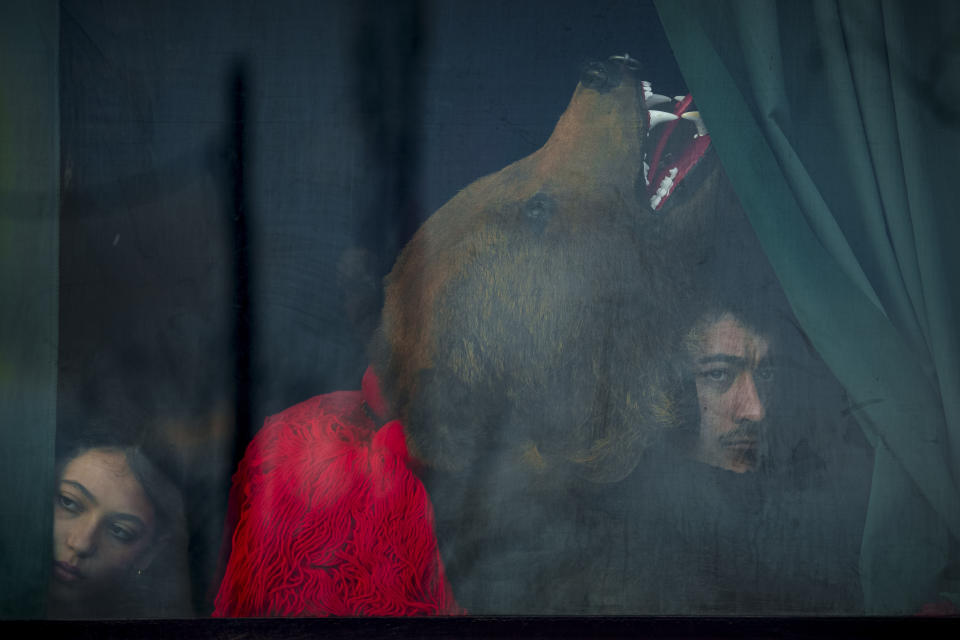 Miembros de un grupo de osos esperan en un bus antes de actuar en un festival en Moinesti, en el norte de Rumanía, el 27 de diciembre de 2023. Hace siglos, quienes vivían en lo que ahora es el noreste de Rumanía se cubrían con pieles de oso y bailaban para ahuyentar a los malos espíritus. Esa costumbre es conocida hoy en día como el Festival del Baile del Oso, que cada diciembre atrae a multitud de turistas. (AP Foto/Vadim Ghirda)