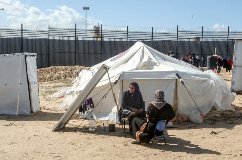 Women sit at tent camp sheltering refugees who have fled fighting between Israeli and Palestinian forces in Rafah in the southern Gaza Strip on February 1. Photo by Ismael Mohamad/UPI