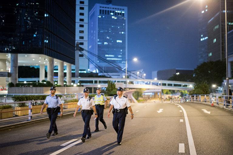 Police patrol an empty highway barricaded by pro-democracy protesters in Hong Kong on October 10, 2014