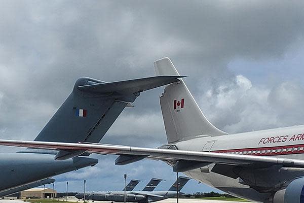 A new report says the Canadian CC150 Polaris, right, rolled backwards into the  French plane, left, while on the ground in Guam in July.  (Royal Canadian Air Force - image credit)