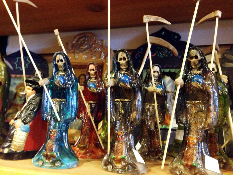 FILE - In this Feb. 13, 2013 file photo, statues of La Santa Muerte, an underworld saint most recently associated with the violent drug trade in Mexico, are shown at the Masks y Mas art store in Albuquerque, N.M. Santa Fe Archbishop John Wester recently told The Associated Press he believes some Catholics may be fooled into venerating Santa Muerte even though the focus on death runs counter to the church's teachings and she's not an official Catholic saint. (AP Photo/Russell Contreras, File)