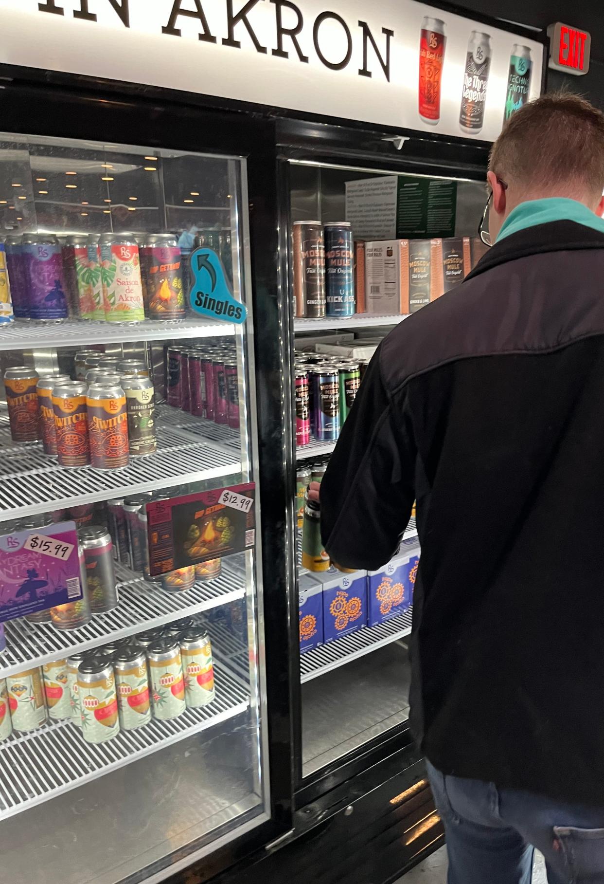 An R. Shea Brewing Co. customer grabs a four-pack of Maple Mashed Sweet Potato, a pastry milk stout and the latest creation at the production brewery in downtown Akron at Canal Place.