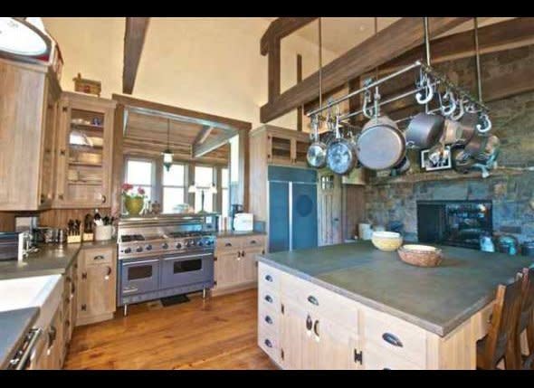 The well-prepped kitchen, which has a heavy-duty range, an hefty pot rack and an expansive stone-top island.